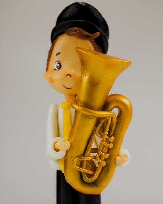 Figurine of a person playing a tuba against a plain background