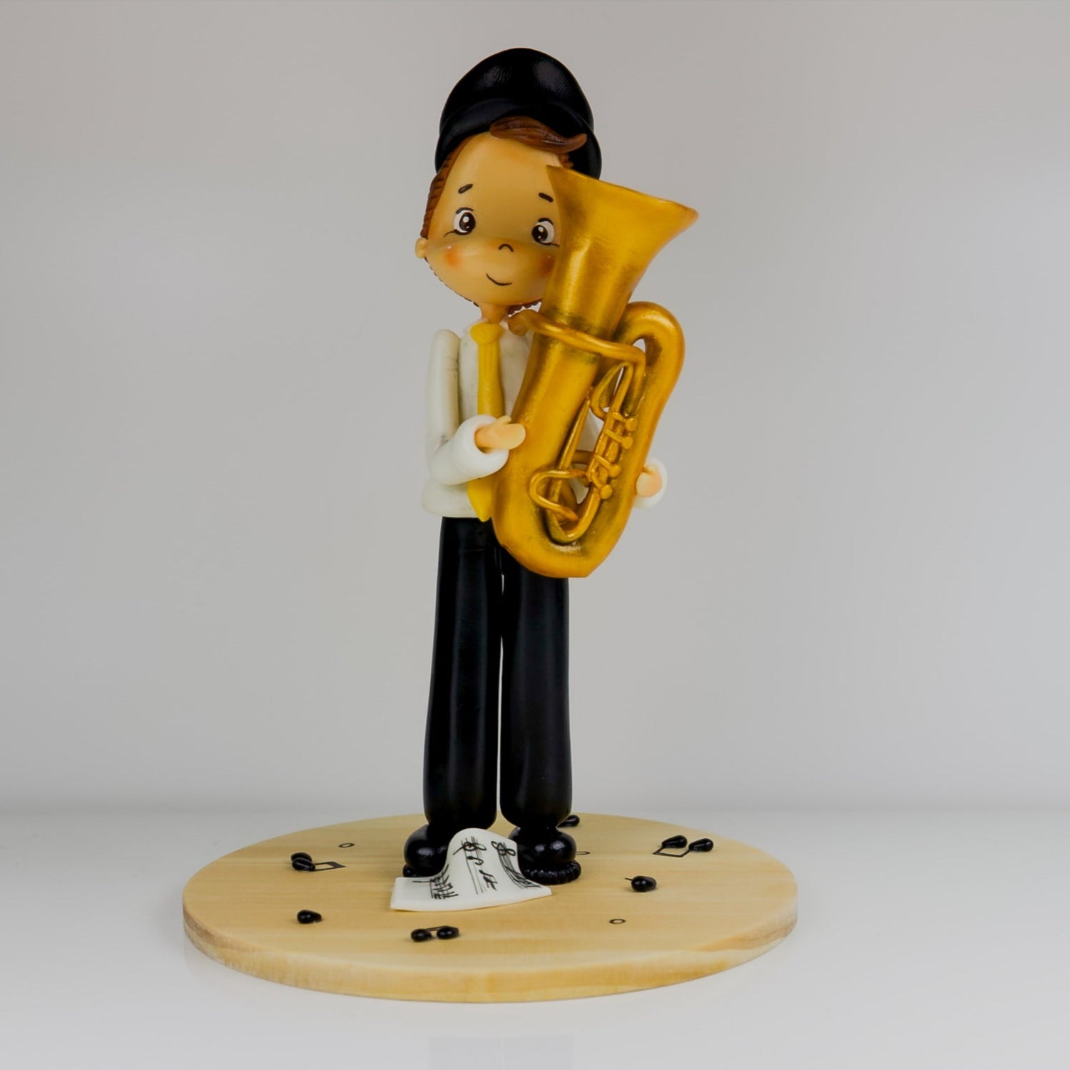 Figurine of a person playing a tuba on a white background