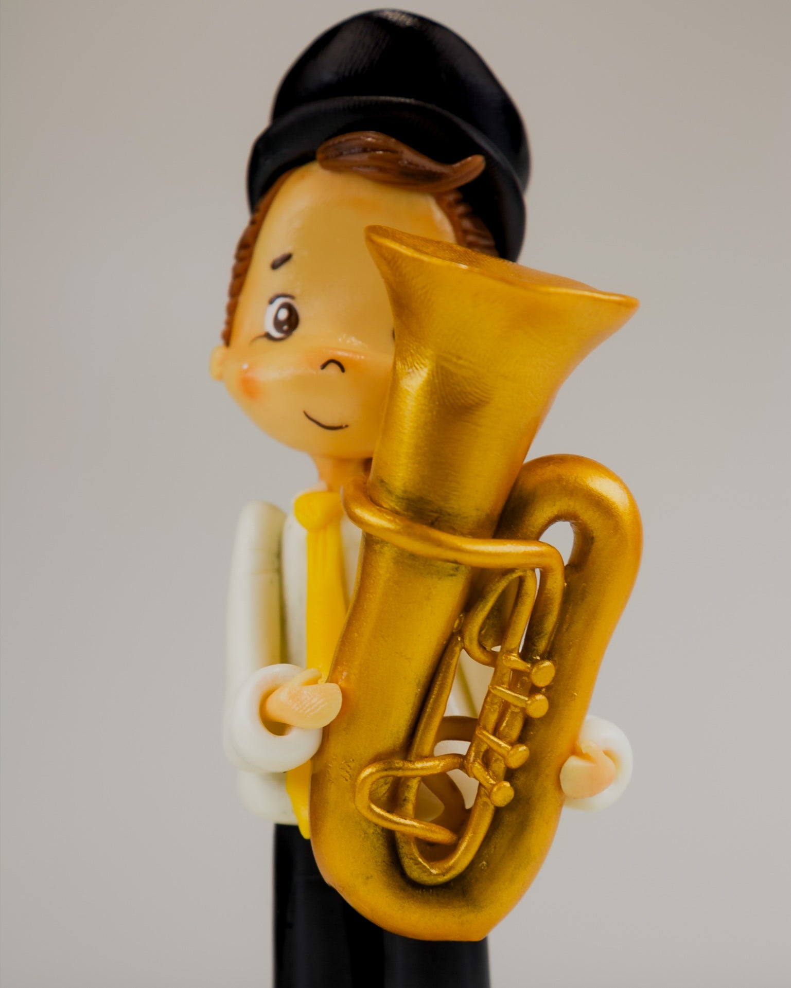 Figurine of a person playing a tuba against a plain background